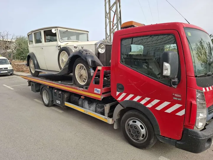 Coche de época sobre una grúa plataforma
