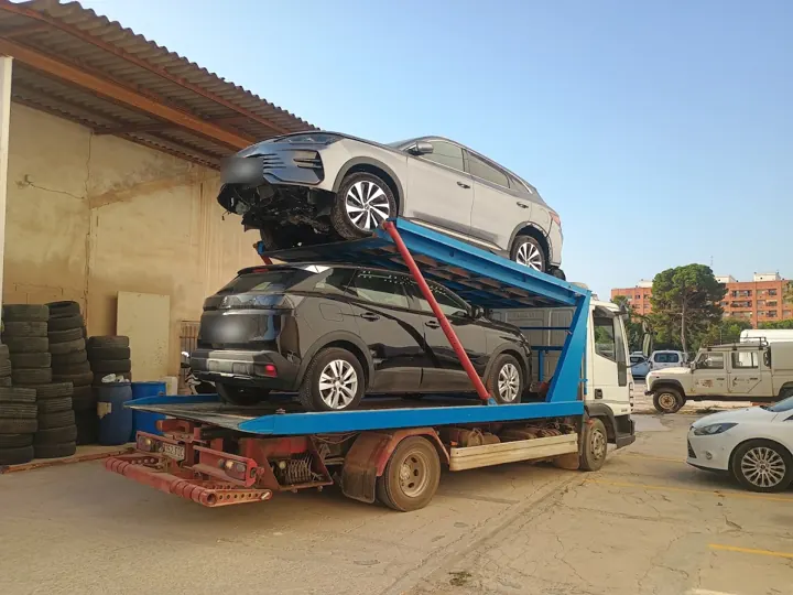 Dos coches cargados a la vez en la grúa plataforma