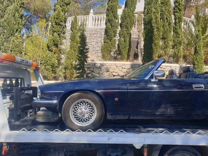 Jaguar descapotable azul sobre la grúa plataforma