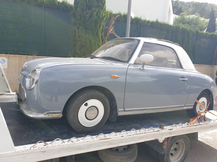 Nissan Figaro sobre la grúa plataforma