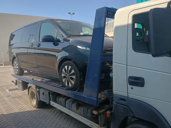 Furgoneta negra cargada en camión plataforma